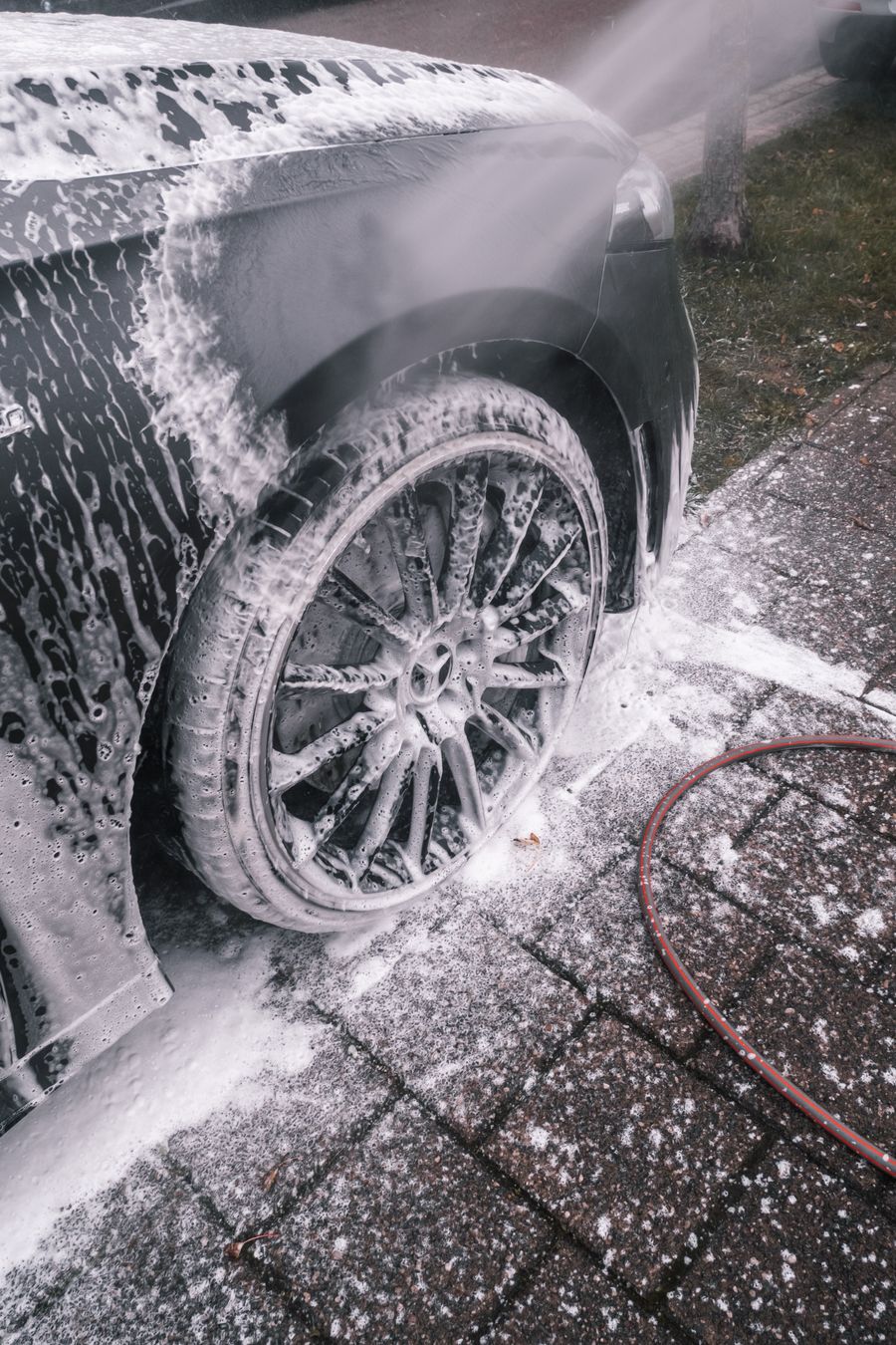 Car wheel covered in foam during an exterior wash